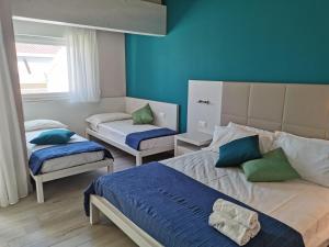 阿布鲁齐的罗塞托Elite Boutique Hotel的一间卧室，有两张床和一面蓝色的墙
