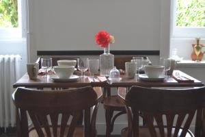 uma mesa de madeira com cadeiras e um vaso de flores em Artefact em Lamballe