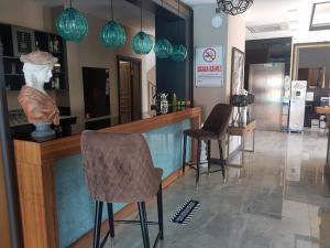 un bar con dos sillas y un jarrón en un mostrador en AMOSSİA Elite Boutique Hotel en Turunc