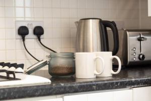 a kitchen counter with two mugs and a coffee pot at Bristol 2 Bedroom Apartment FREE PARKING in Bristol