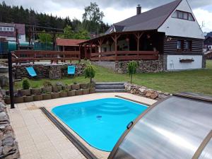 a large swimming pool in front of a house at Šumavská rekreační chalupa in Pohorsko