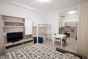 ein Schlafzimmer mit einem Bett und einem Tisch sowie eine Küche in der Unterkunft Appartamento a 3 passi dal mare in Varraze