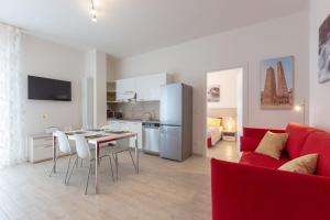 eine Küche und ein Wohnzimmer mit einem roten Sofa und einem Tisch in der Unterkunft Enjoy, Bologna by Short Holidays in Bologna