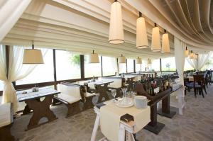 a restaurant with tables and chairs and large windows at Sea View Marina Dinevi Apartments - Tryavna Beach in Sveti Vlas