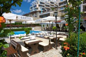 a patio with tables and umbrellas next to a pool at Sea View Marina Dinevi Apartments - Tryavna Beach in Sveti Vlas