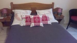 Una cama con cuatro almohadas encima. en Chez Louis chambres d'hôtes à la ferme, en La Canourgue