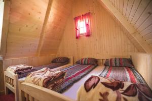 two beds in a log cabin with a window at Rafting Center Drina Tara in Bastasi