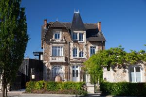 an old stone house with a black fence at Manoir Henri Giraud & Spa in Épernay