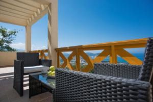 patio z krzesłami i stołem z widokiem na ocean w obiekcie Berg Apartments w Barze