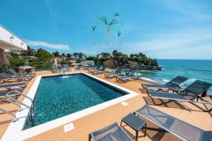 a swimming pool with chairs and the ocean in the background at Plaza Hotel&SPA in Ulcinj