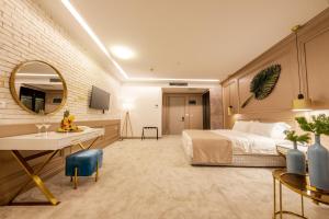 1 dormitorio con cama, escritorio y espejo en Plaza Hotel&SPA, en Ulcinj