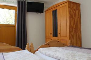 - une chambre avec 2 lits et une armoire en bois dans l'établissement Appartment am Trätzhof, à Fulde