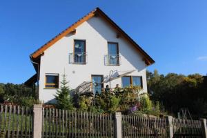 a white house with a fence in front of it at Appartment am Trätzhof in Fulda