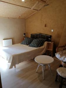 Un dormitorio con una cama y una mesa. en Chambres d'hôtes "La Source", en Mareuil-sur-Lay