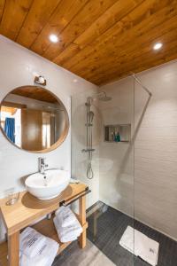 a bathroom with a sink and a shower at LAS RIBERAS. APARTAMENTOS RURALES in Oviñana