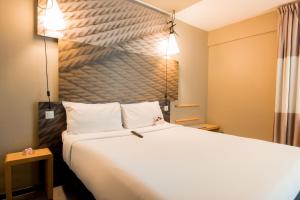 a hotel room with a large bed and two lights at ibis Alger Aéroport in Alger