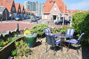 een terras met een tafel en stoelen en een straat bij Strandhuis Everts in Egmond aan Zee