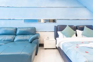 a blue room with a couch and a bed at Louidon Mega Apartment Hotel Of Kam Rueng Plaza - Sunshine Apartment in Guangzhou