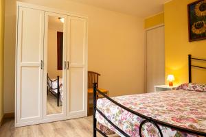 een slaapkamer met een bed en een deur met een spiegel bij Appartamento Galet in Ledro