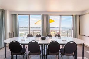 a conference room with a table and chairs and windows at Best Western Hôtel Royan Océan in Royan