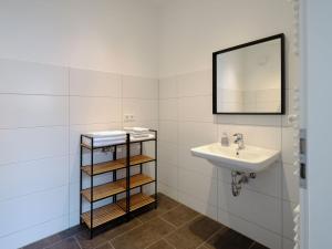 a bathroom with a sink and a mirror at Travel Art Boardinghouse in Neuruppin +19 photos