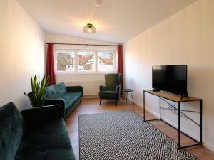 Travel Art Boardinghouse في نيوروبين: غرفة معيشة مع أريكة وتلفزيون بشاشة مسطحة