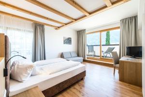 a bedroom with a large bed and a television at Hotel-Garni Ehrenfels in Schenna