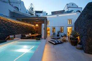 una villa con piscina di fronte a una casa di Floria Suites a Karterados