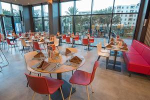 a restaurant with tables and chairs and windows at ibis Alger Aéroport in Alger