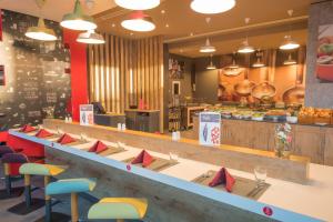 a restaurant with a row of tables and chairs at ibis Alger Aéroport in Alger