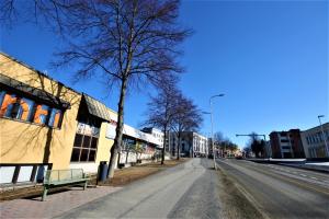 una calle urbana vacía con un banco y edificios en Forenom Aparthotel Kuopio, en Kuopio