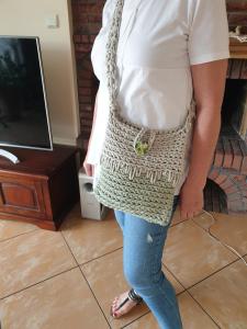 a woman in a white shirt holding a crochet purse at Apartamenty i pokoje u Beaty in Augustów