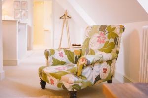 a green and pink floral chair in a living room at The Hero in Burnham Market