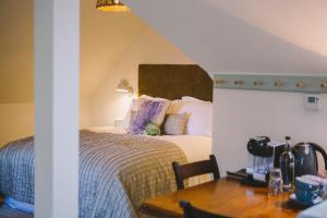 - une chambre avec un lit et une table en bois dans l'établissement The Hero, à Burnham Market