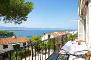 a balcony with a table and chairs and a view of the water at Apartments Kalina in Jelsa