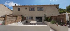 een huis met een tafel en stoelen ervoor bij Les Prairies de l'Encrême in Céreste