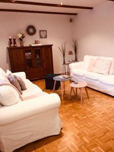 a living room with two white couches and a table at Ferienwohnung Jette mit Wallbox in Hanstedt