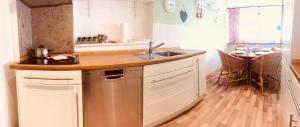 a kitchen with a sink and a wooden floor at Ferienwohnung Jette mit Wallbox in Hanstedt