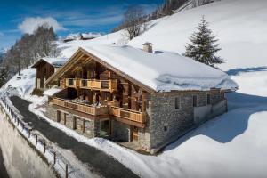 una casa de madera en la nieve cubierta de nieve en Chalet Goville - OVO Network en La Giettaz