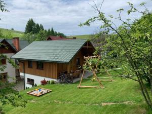 a house with a playground in the yard at Domki U Moniki in Grywałd