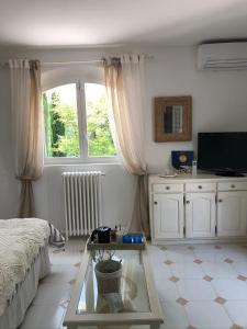 uma sala de estar com uma cama e uma mesa de vidro em Villa Oïa em Lorgues