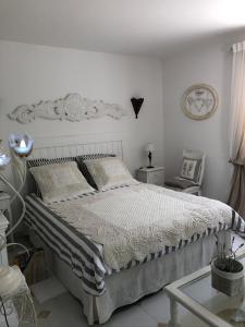 ロルグにあるVilla Oïaの白いベッドルーム(大型ベッド1台、椅子付)