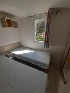 a white bed sitting in a bedroom next to a window at U Pezzo in Saint-Florent