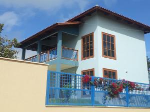 a white house with a blue fence at Vivendas da Serra Chalés in Martins