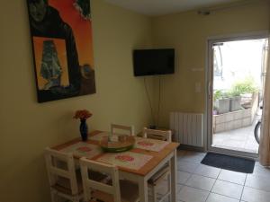 a dining room with a table and a television at L'Escale VICHY in Vichy