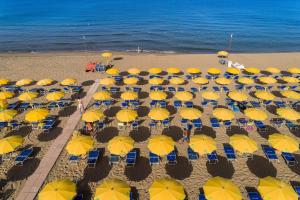 una vista aérea de una playa con sombrillas amarillas en Hotel Le Palme en Paestum