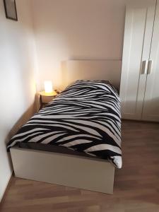 uma cama com um cobertor de zebra preto e branco em Ferienwohnung Wittenberge em Wittenberge