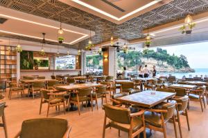 un restaurante con mesas y sillas y vistas al océano en Plaza Hotel&SPA, en Ulcinj