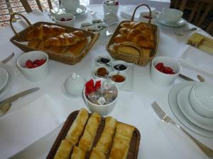 uma mesa com pão, croissants e outros alimentos em La Maison du Môle em Aigues-Mortes