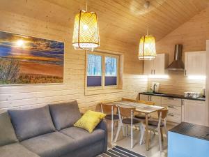 a living room with a couch and a table at Mistral przy plaży Domki całoroczne in Ustka